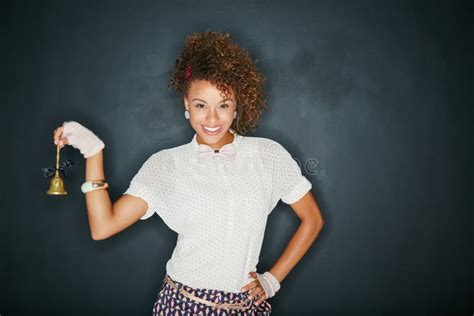 Ring a Ding Ding. Studio Portrait of an Attractive Young Woman Ringing a Small Bell Against a ...