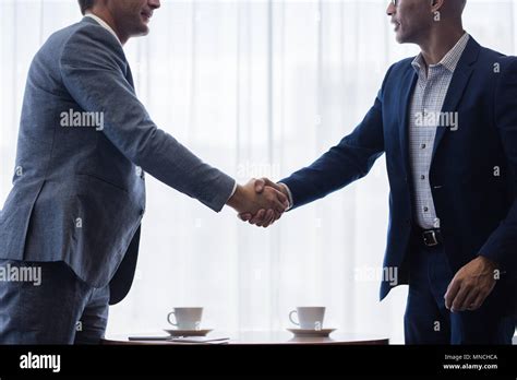 Two business men shaking hands with each other after a deal ...