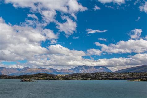 On the Shore of Shallow Lake | Mountains rise in the distance on the ...