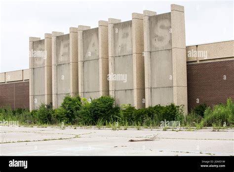 A logo sign outside of a closed and abandoned Sears retail store in ...