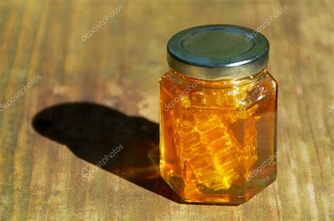 Jar of honey with honeycomb on wood — Stock Photo © sorsillo #40976155