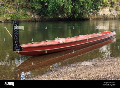 A Maori waka (a traditional canoe with ornamental carvings) on the Waikato River, New Zealand ...