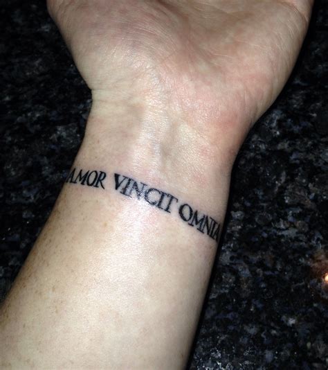 Wrist tattoo Amor Vincit Omnia - Love Conquers All | Amor tattoo, Tattoos, Wrist tattoos