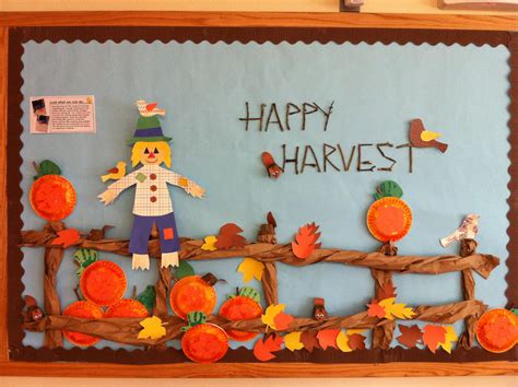 a bulletin board with an image of a scarecrow and pumpkins on it that says happy harvest