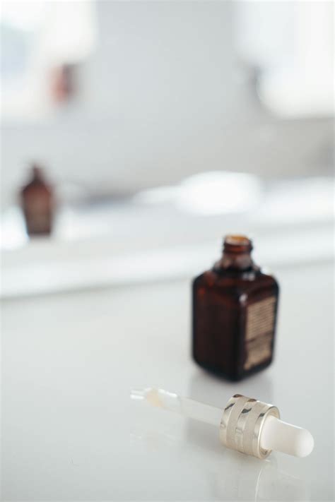 Bottle of essential oil near pipette on table · Free Stock Photo
