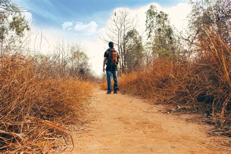 man in blue denim jean and black shirt walking on pathway during daytime free image | Peakpx