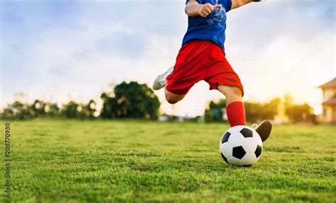 An action sport picture of a group of kids playing soccer football for ...