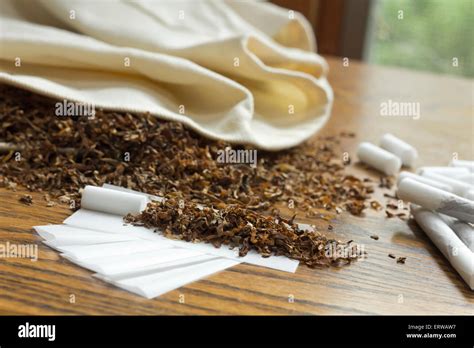 Rolling cigarettes with filters papers and plenty finely cut tobacco Stock Photo - Alamy