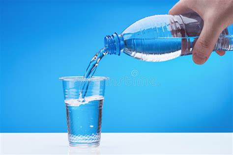 Pour Water from Plastic Bottle into Clear Plastic Cup. Bottle in Hand of Man. Stock Photo ...