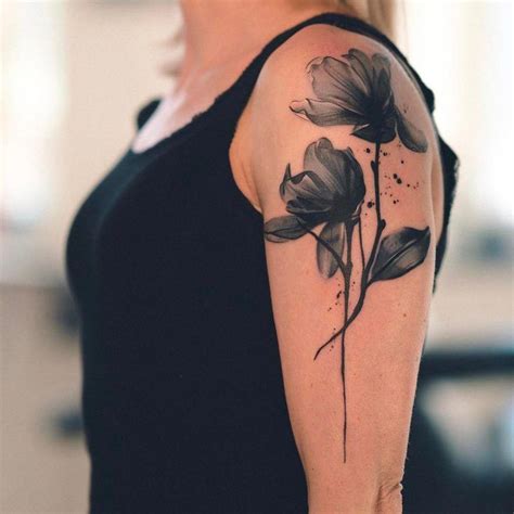 Black watercolor flower tattoo on the left upper arm # ...