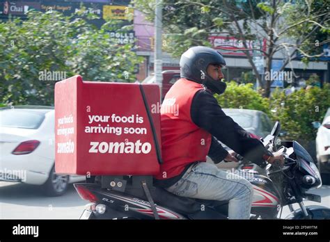 Zomato delivery boy with red hot box for food on a bike zooming at high ...