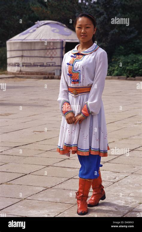 Young Mongolian woman in traditional costume with a yurt or ger tent in ...