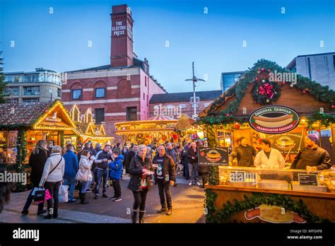 View of visitors and Christmas Market stalls at Christmas Market, Millennium Square, Leeds ...