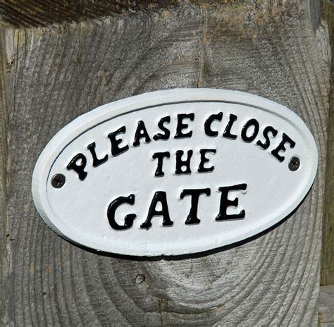 Traditional white cast metal please close the gate sign