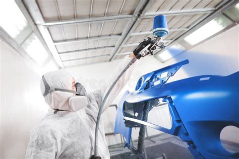 Male Worker Sprays Blue Paint with Spray Gun on Car Body Part in Car ...