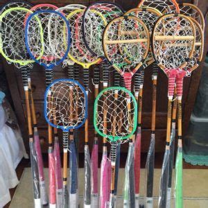 many different colored badminton racquets are lined up on a racket holder