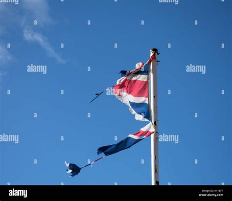 Wind damaged flag of Great Britain flying in high winds Stock Photo - Alamy