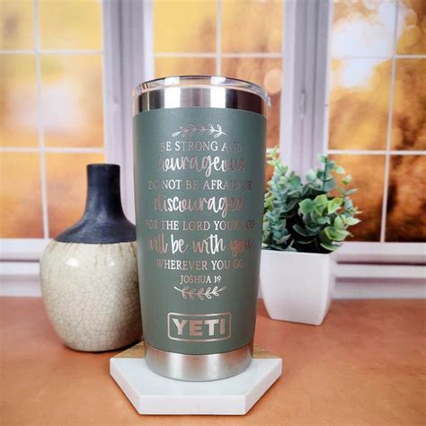 a green yeti tumbler sitting on top of a table next to a vase