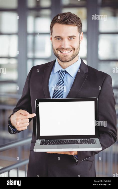 Happy businessman showing laptop Stock Photo - Alamy