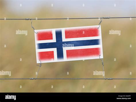 Border fence - Old plastic sign with a flag - Norway Stock Photo - Alamy