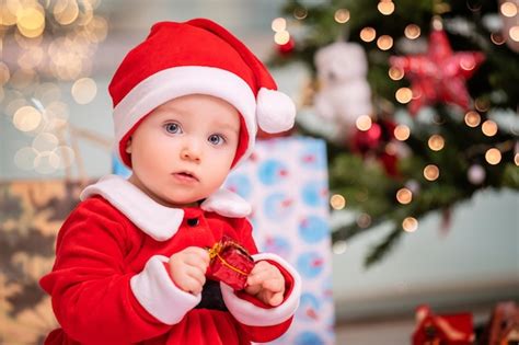 Premium Photo | An adorable kid dressed as santa claus plays near a ...