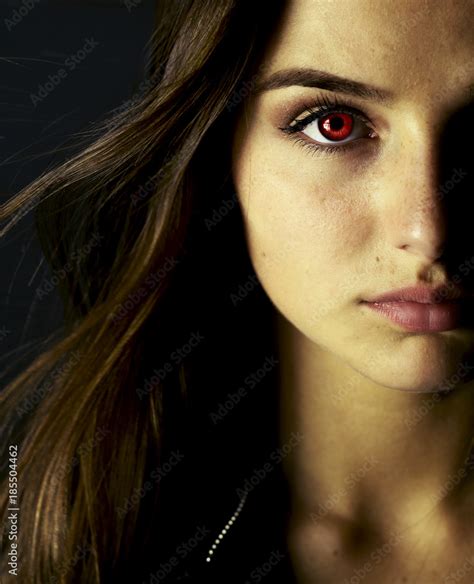 Portrait of beautiful vampire young woman with red eyes. Stock Photo | Adobe Stock