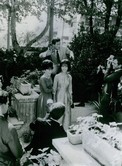 Press people taking photographs of Madame Nhu, First Lady of South Vietnam, with her daughter ...