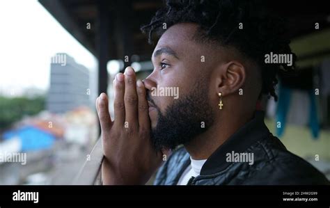 A young black man praying to God person opening eyes to sky smiling Stock Photo - Alamy