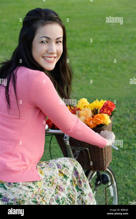 Young woman on bike looking back over shoulder Stock Photo - Alamy