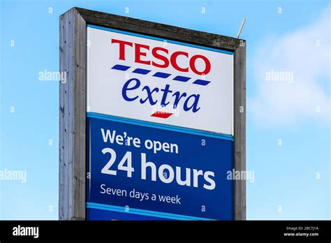 Tesco supermarket logo advertising the opening hours - 24 hours per day and seven days a week ...