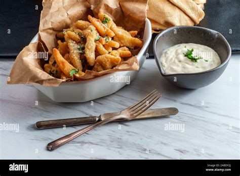 New England fried clam strips served with a bowl of tartar dipping ...