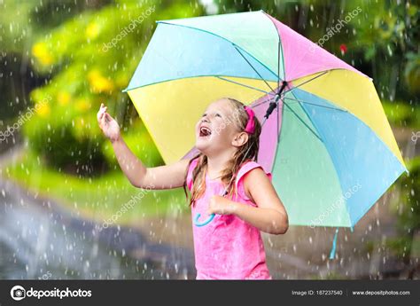 Kid with umbrella playing in summer rain. Stock Photo by ©FamVeldman ...