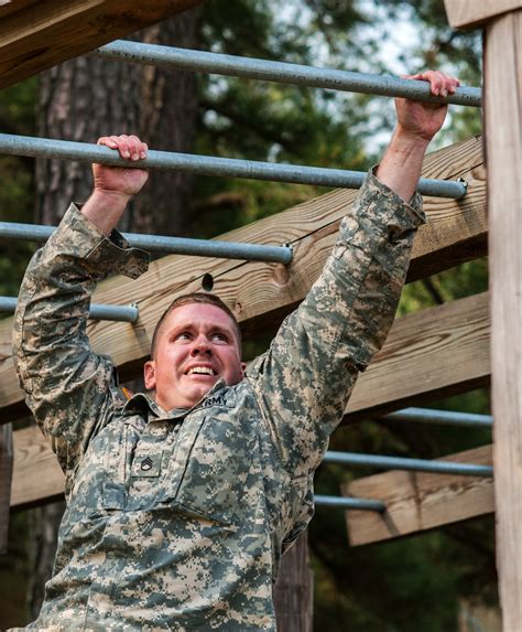 Army Staff Sgt. Zachary Fink traverses the horizontal ladder obstacle ...