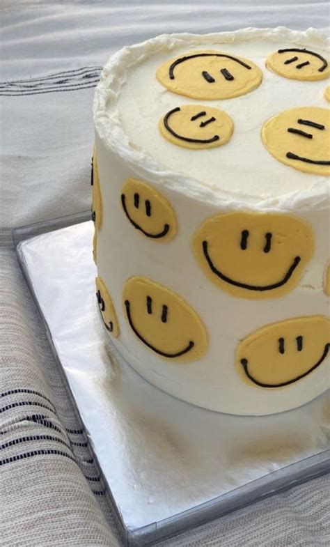 a cake with smiley faces on it sitting on top of a table next to a napkin