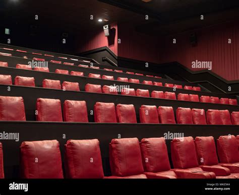 Rows of luxury red movie theater seats in an empty movie theater Stock ...