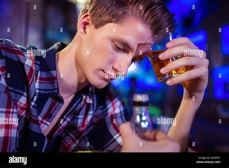 Sad man holding whiskey glass Stock Photo - Alamy