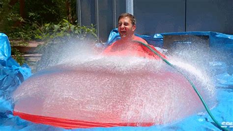 Watch a giant water balloon explode in slow motion with a man inside it