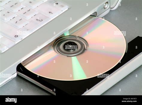 Inserting a CD into a CD rom drive on a laptop computer Stock Photo - Alamy