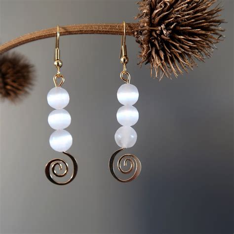 bridget of satin crystals wearing white selenite gold spiral dangle earring Swirl Earrings ...