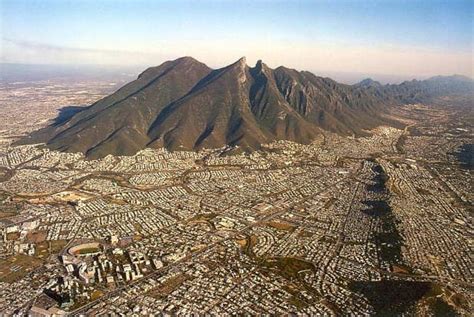 an aerial view of a city with mountains in the background