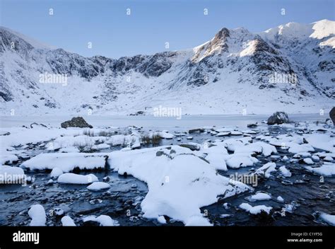 View across frozen Llyn Idwal lake to the Devil's Kitchen and Y Garn in ...