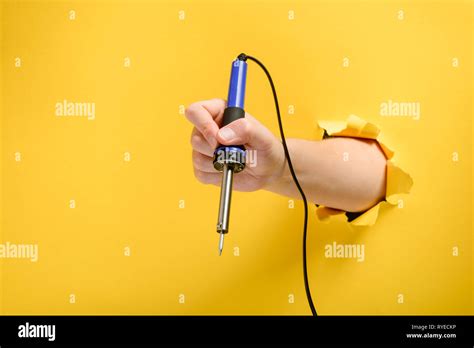 Hand holding a soldering iron Stock Photo - Alamy