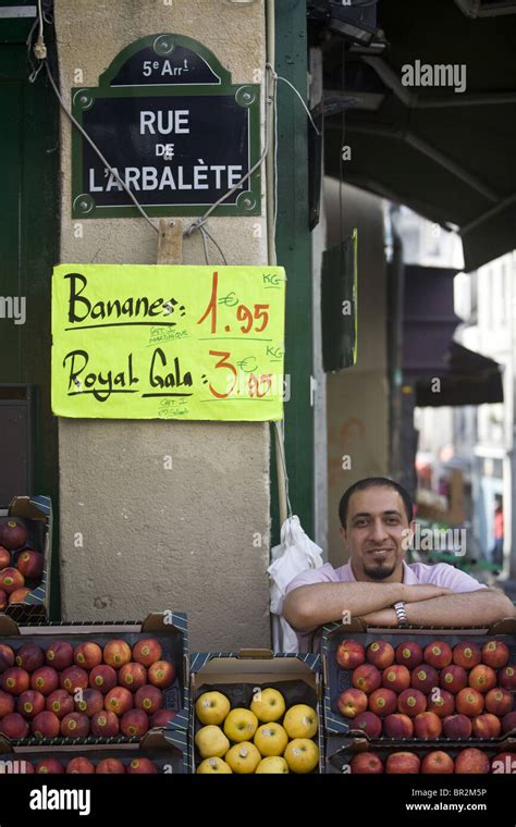 A market stall holder selling fruit from his stall in the market on Rue Mouffetard, a celebrated ...