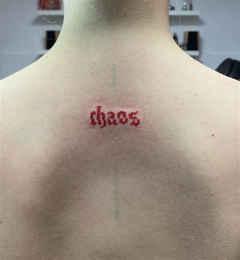 the back of a man's neck with an inscription that reads chaos on it