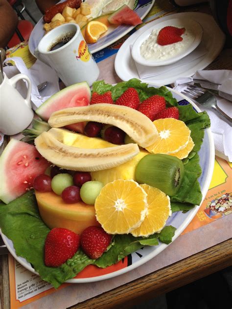 a plate filled with fruit and vegetables on top of a table