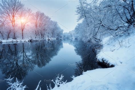 Winter forest on the river at sunset. Colorful landscape with snowy ...