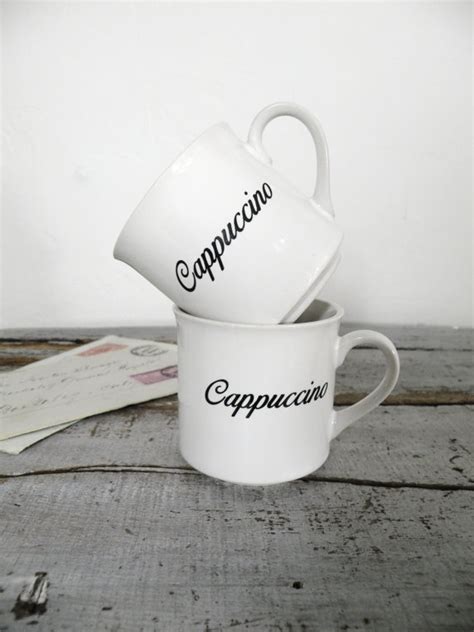 two cups with the words cappuccino and cappuccino written on them