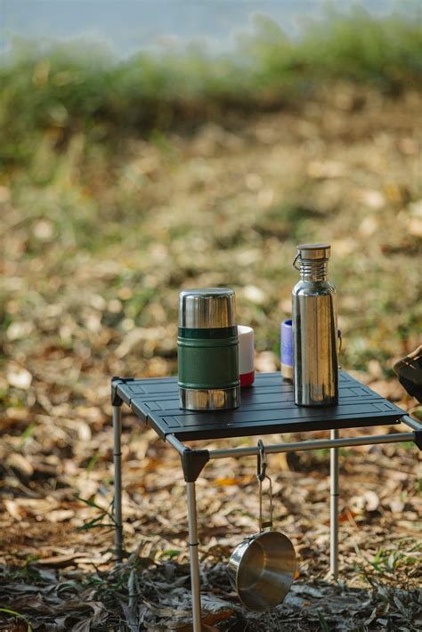Portable table with vacuum flasks on coast · Free Stock Photo