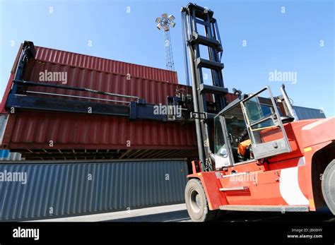 Forklift truck lifting shipping container Stock Photo - Alamy