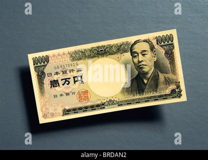 Japanese 10,000 yen banknotes overlapping each other in a long line on a plain white background ...